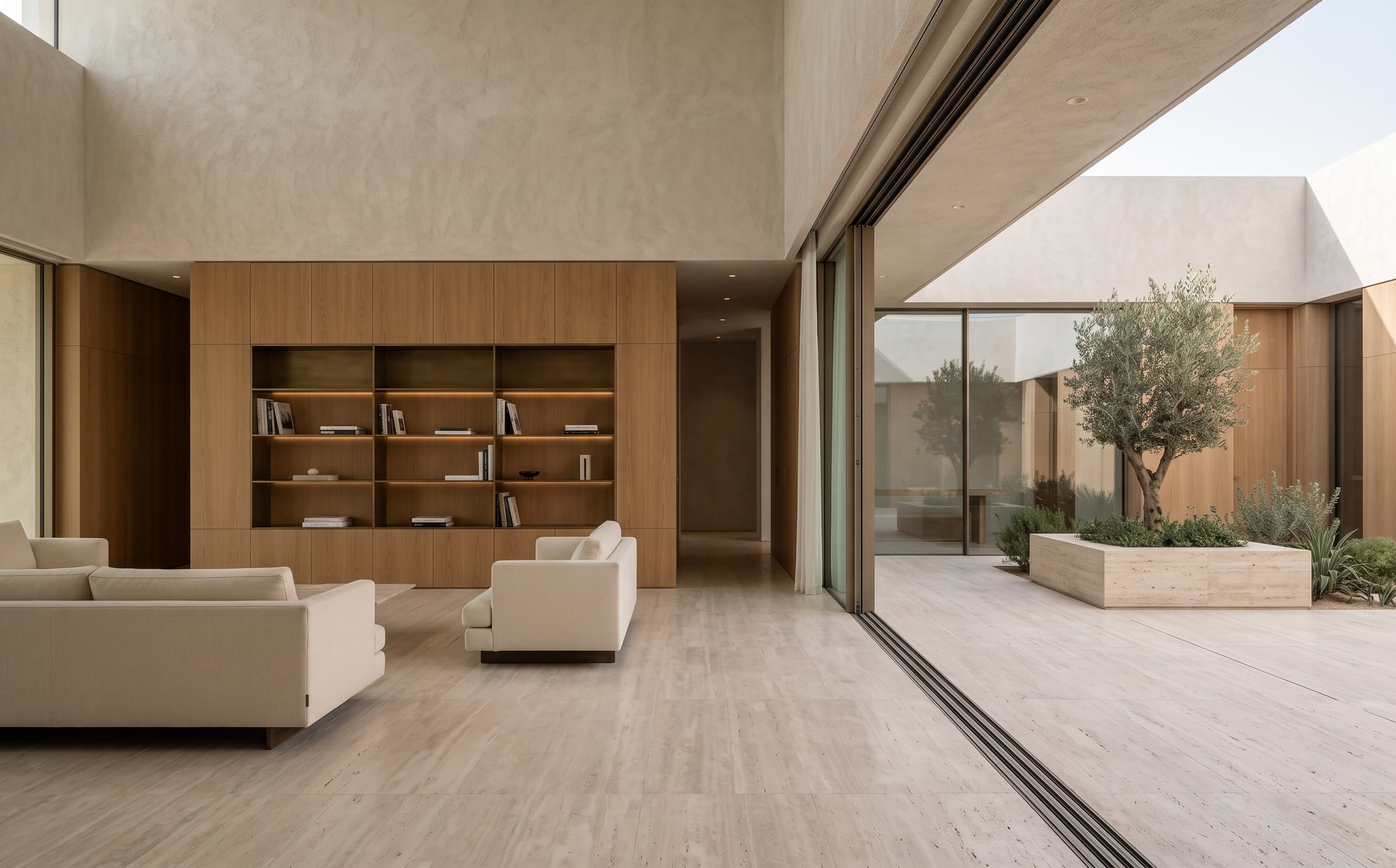 The living space of Dune House in travertine, warm oak and textured plaster